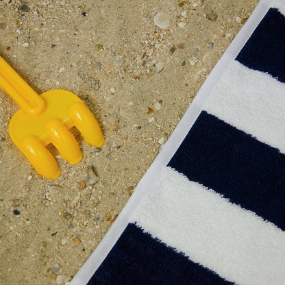 Détails coin de la serviette intemporelle de LAMANIAK inspirée de DEAUVILLE avec ses rayures bleu marine et blanche fabriquée en 100% coton en FRANCE 