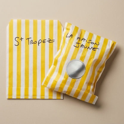Un packaging jaune avec ses accessoires et un bijou argenté